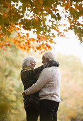Older couple hugging in park - CAIF02389