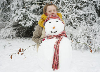 Mädchen macht Schneemann im Freien - CAIF02444