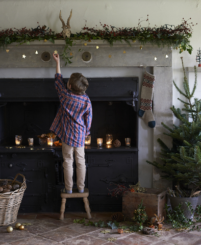 Junge dekoriert Weihnachtskamin, lizenzfreies Stockfoto