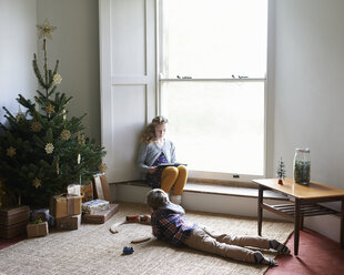 Kinder entspannen sich am Weihnachtsbaum - CAIF02459