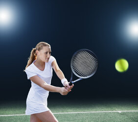 Tennis player hitting ball on court - CAIF02516