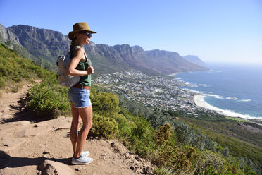South Africa, Cape Town, woman standing looking at the coast during hiking trip to Lion's Head - ECPF00220