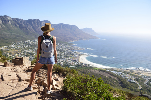 Südafrika, Kapstadt, Frau stehend mit Blick auf die Küste beim Wanderausflug zum Lion's Head, lizenzfreies Stockfoto