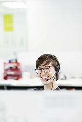 Businesswoman wearing headset in office - CAIF02572