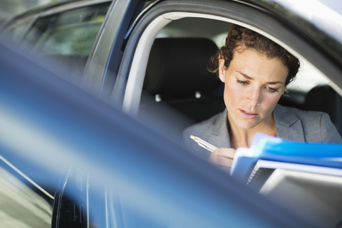 Geschäftsfrau arbeitet im Auto, lizenzfreies Stockfoto