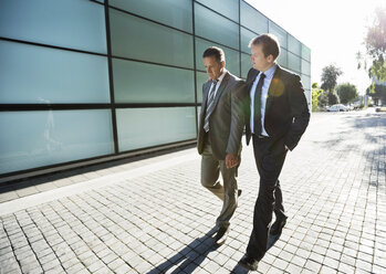 Businessmen walking on city street - CAIF02665