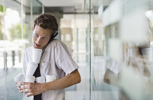 Geschäftsmann balanciert Kaffee im Büro - CAIF02666