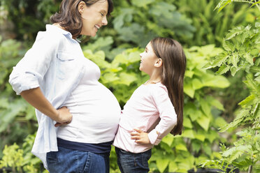 Mädchen stößt gegen den Bauch der schwangeren Mutter - CAIF02672