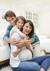 Family hugging in living room - CAIF02679