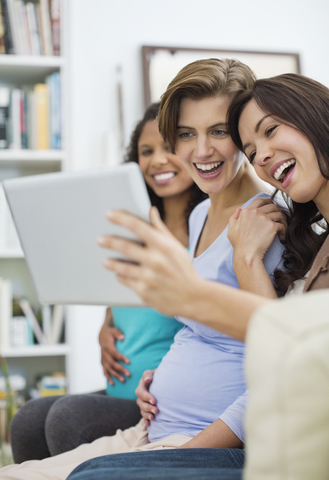 Frauen benutzen gemeinsam einen Tablet-Computer, lizenzfreies Stockfoto