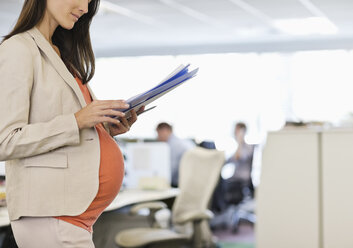 Schwangere Geschäftsfrau bei der Arbeit im Büro - CAIF02702