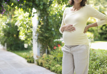 Pregnant woman standing outdoors - CAIF02703
