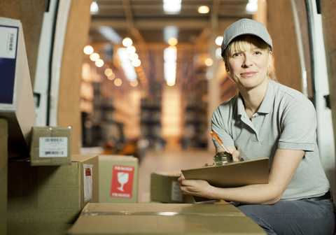 Delivery girl checking boxes in van stock photo