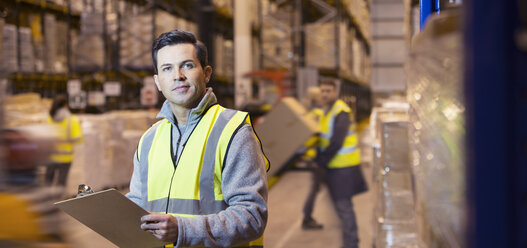 Worker using clipboard in warehouse - CAIF02780