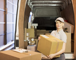 Delivery girl unloading boxes from van - CAIF02786