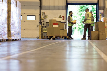 Workers talking in warehouse - CAIF02795