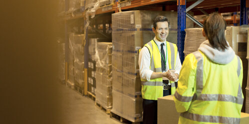 Workers talking in warehouse - CAIF02799