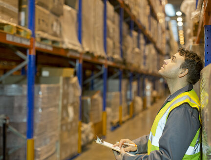 Worker checking boxes in warehouse - CAIF02806