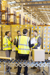 Businessman and workers talking in warehouse - CAIF02821