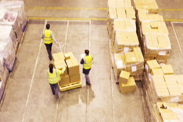 Arbeiter transportieren Kisten im Lager - CAIF02822
