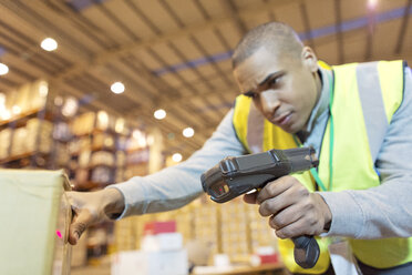 Worker scanning boxes in warehouse - CAIF02830