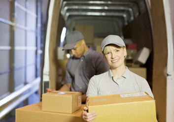 Delivery people loading boxes into van - CAIF02846