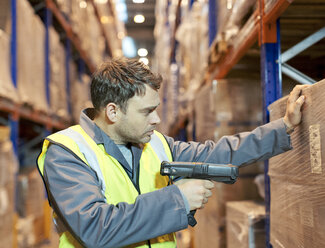 Worker scanning boxes in warehouse - CAIF02856