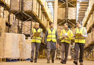 Workers talking in warehouse - CAIF02873