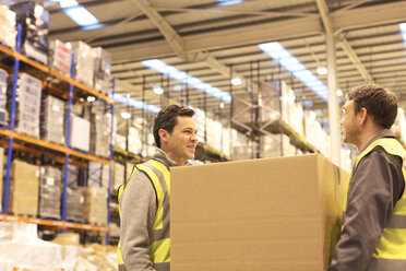 Workers carrying box in warehouse - CAIF02875