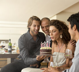 Woman blowing out birthday candles - CAIF02916