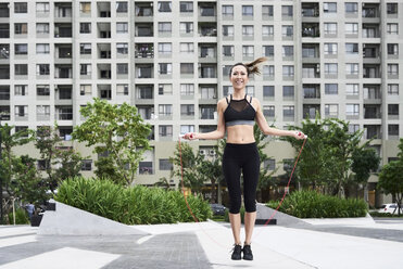 Fit woman skipping rope in urban environment - IGGF00462