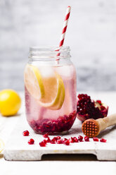 Fruit infused water with lemon slices, crushed pomegranate seeds and sparkling water - SBDF03472