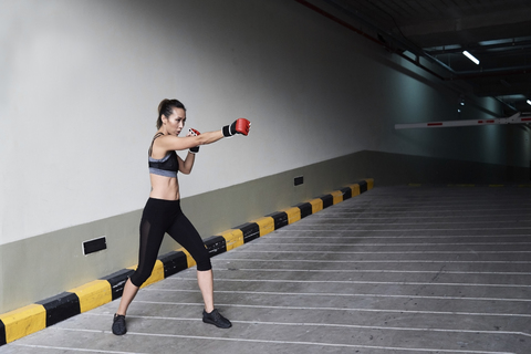 Female boxer boxing in a garage stock photo