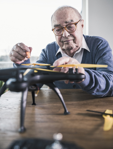 Porträt eines älteren Mannes bei der Arbeit an einer Drohne, lizenzfreies Stockfoto
