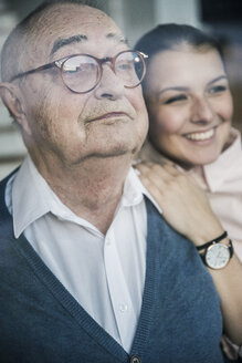 Porträt einer lächelnden jungen Frau mit einem älteren Mann am Fenster - UUF12909