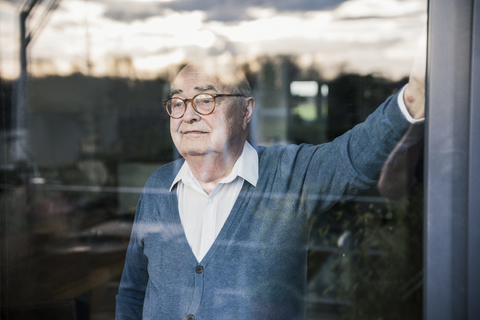 Portrait of serious man at the window looking out stock photo
