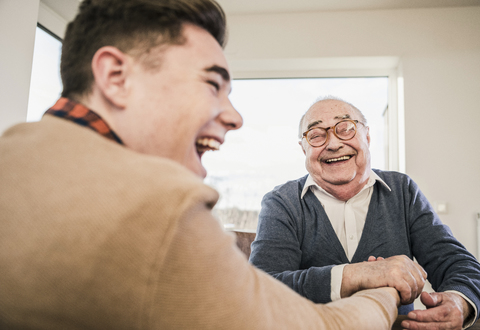 Happy senior man and young man arm wrestling stock photo