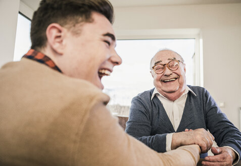 Happy senior man and young man arm wrestling - UUF12917