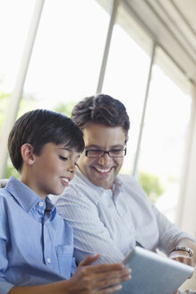 Father and son using tablet computer - CAIF02978