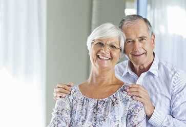 Older couple smiling together indoors - CAIF03004
