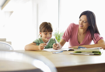 Mother helping daughter with homework - CAIF03015