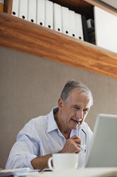 Older man working at desk - CAIF03019