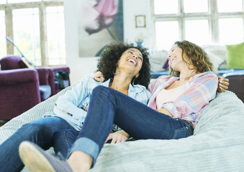 Women relaxing in beanbag chair together - CAIF03099