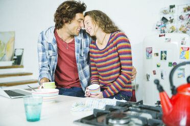 Couple relaxing together in kitchen - CAIF03113