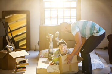 Couple unpacking boxes in attic - CAIF03136