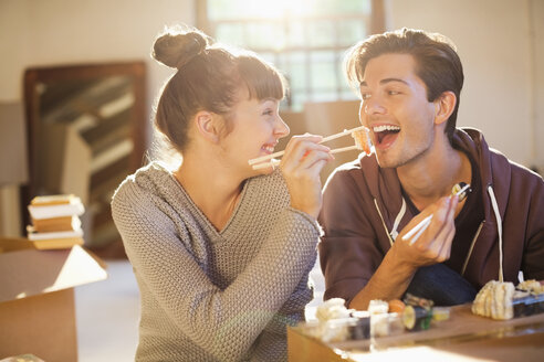 Ehepaar isst gemeinsam Sushi im neuen Haus - CAIF03155