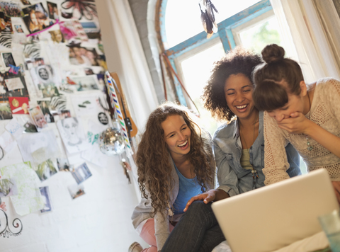 Frauen benutzen Laptop zusammen im Schlafzimmer, lizenzfreies Stockfoto