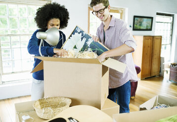 Couple unpacking boxes in new home - CAIF03181