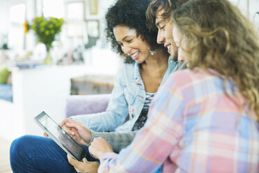 Freunde benutzen Tablet-Computer auf dem Sofa - CAIF03187