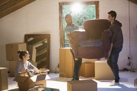 Freunde ziehen mit Möbeln in eine neue Wohnung, lizenzfreies Stockfoto